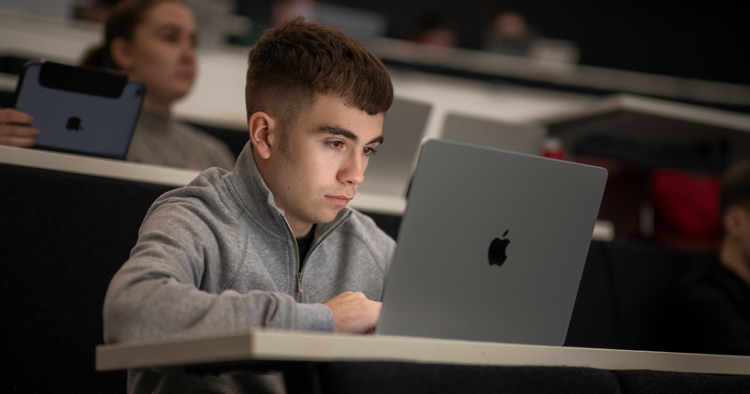 Student používá iPhone a Mac s funkcemi zpřístupnění