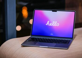 MacBook na stole vedle grafu poklesu notebookového trhu