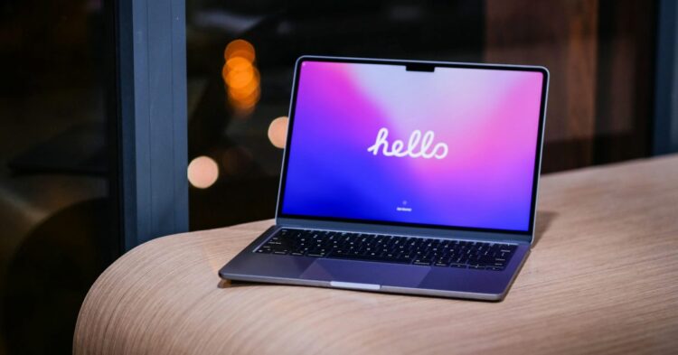 MacBook na stole vedle grafu poklesu notebookového trhu