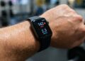 Apple Watch na zápěstí vedle baterie a evropských pravidel