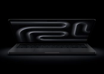 MacBook na stole s cenovkou a grafem poklesu trhu notebooků