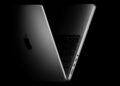 MacBook Pro na stole vedle OLED displeje